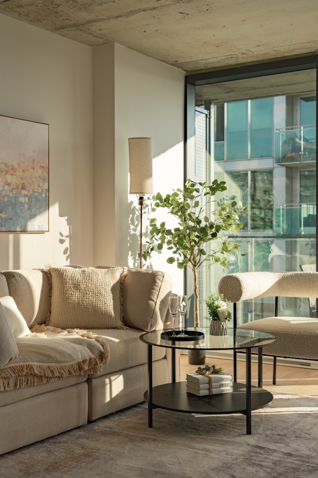 Sunlit apartment seating area with sofa, chair, and coffee table