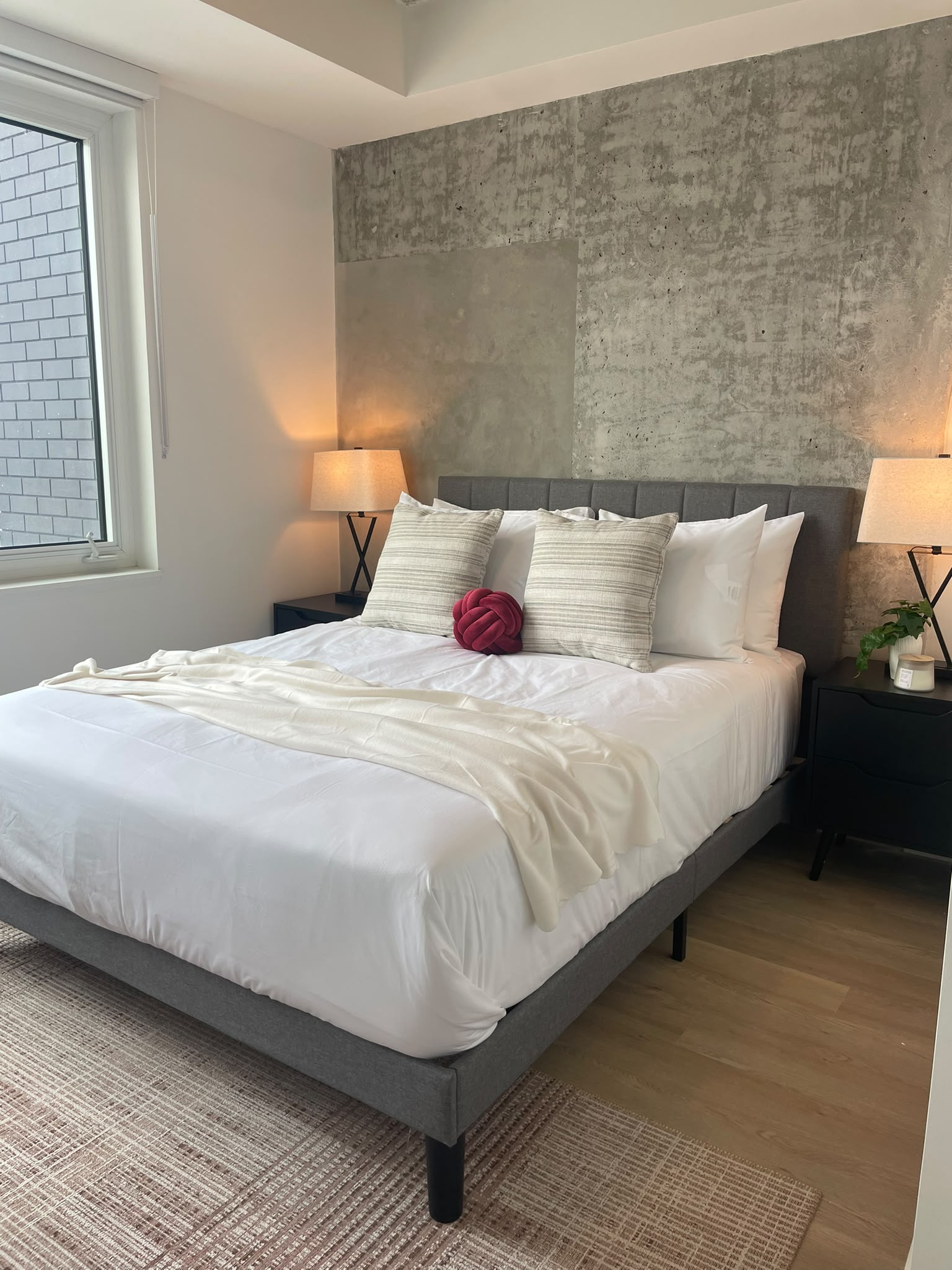 Finished bedroom with a queen bed, coordinated linens, bedside tables, and lamps